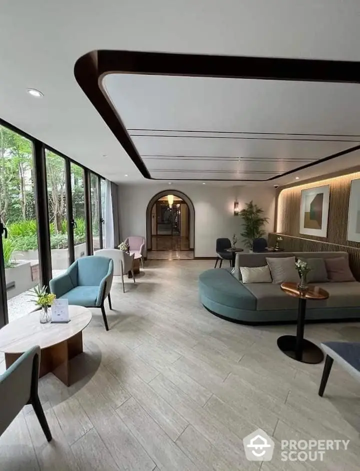 Expansive and elegantly designed living room with modern furnishings, large windows offering lush garden views, and a unique curved ceiling feature.