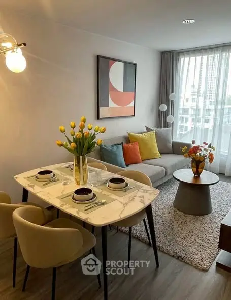 Stylish living room with modern decor and dining area, featuring a cozy sofa and elegant table setting.