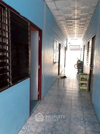 Bright corridor with blue walls and patterned tile flooring in residential building.