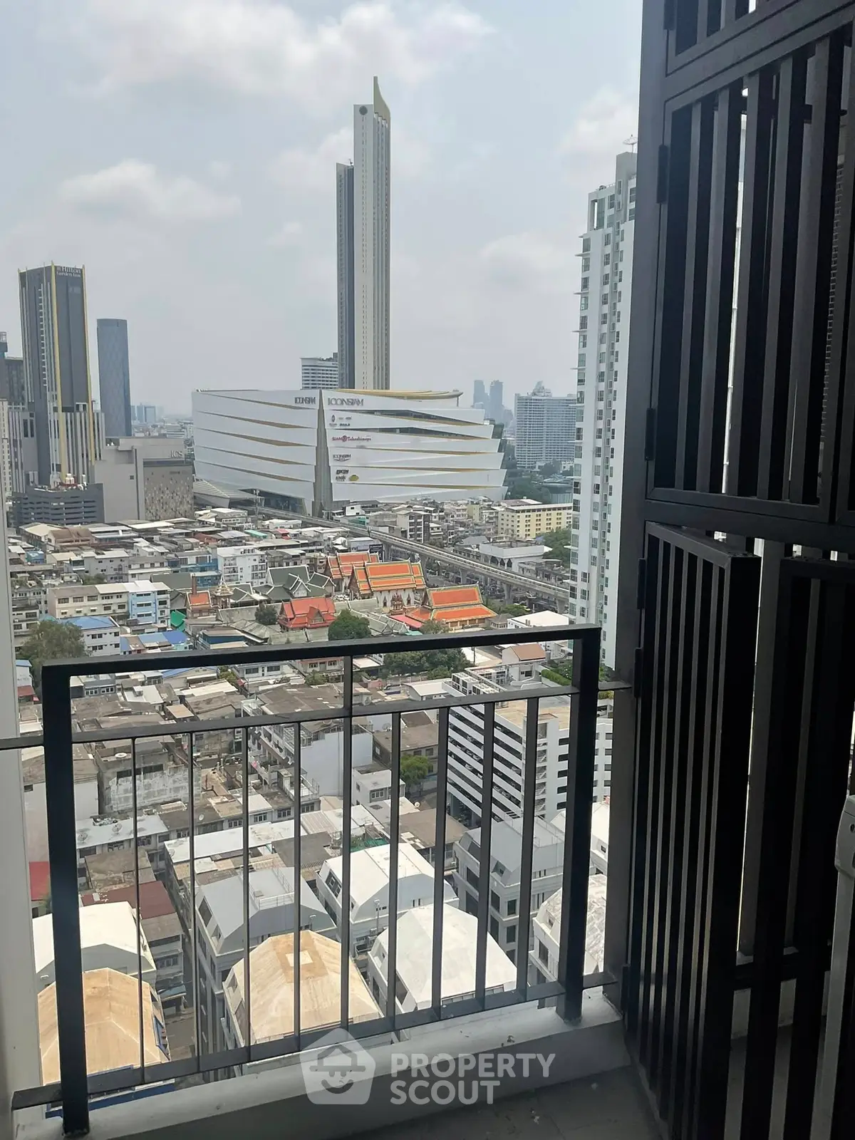 Stunning cityscape view from a high-rise balcony, showcasing urban skyline and modern architecture.