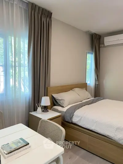 Cozy bedroom with modern decor and natural light, featuring a comfortable bed and stylish furnishings.