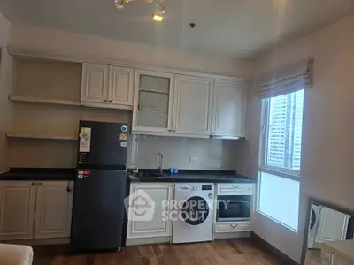 Modern kitchen with appliances including fridge, washing machine, and oven in a stylish apartment.