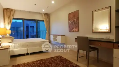 Spacious bedroom with modern decor and large window in a stylish apartment.