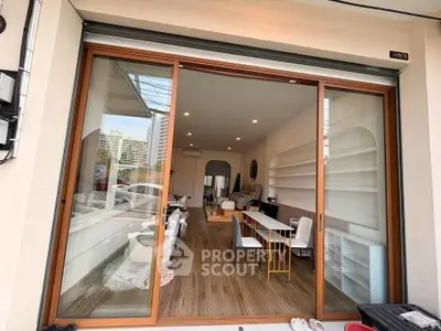 Spacious modern interior with wooden flooring and large glass doors, ideal for versatile commercial use.