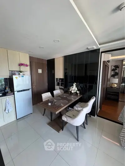 Modern dining area with sleek furniture and open kitchen layout in a stylish apartment.