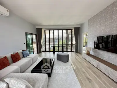 Spacious modern living room with elegant decor and large windows offering natural light.