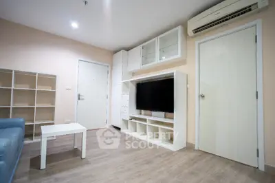 Modern living room with sleek furniture and wall-mounted TV in a cozy apartment.