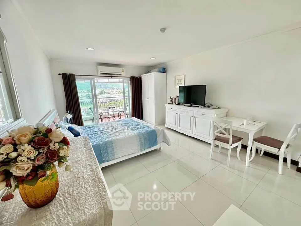 Spacious studio apartment with modern decor and balcony view
