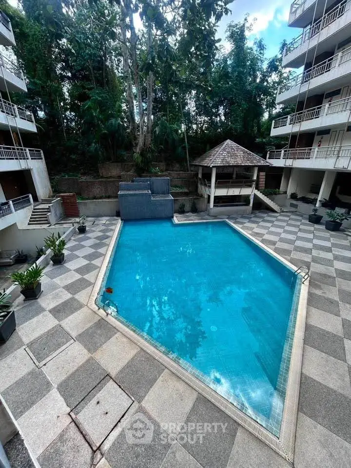 Stunning residential complex with a sparkling pool surrounded by lush greenery and modern architecture.