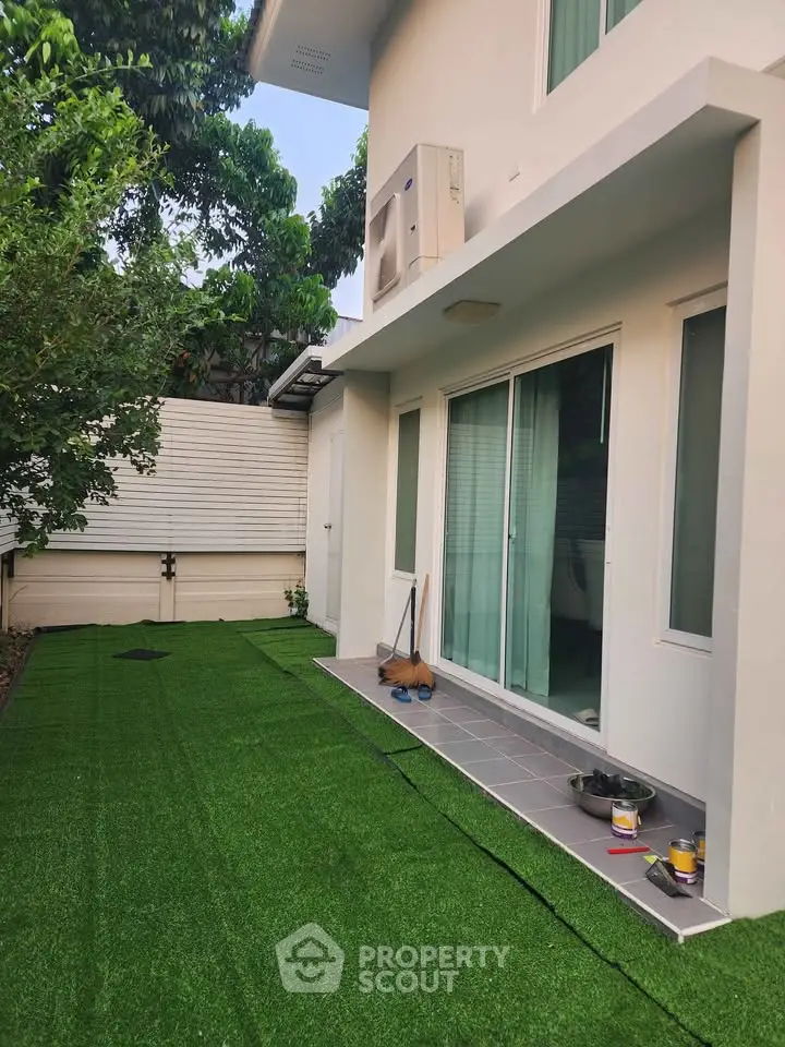 Charming backyard with artificial grass and modern patio in a suburban home