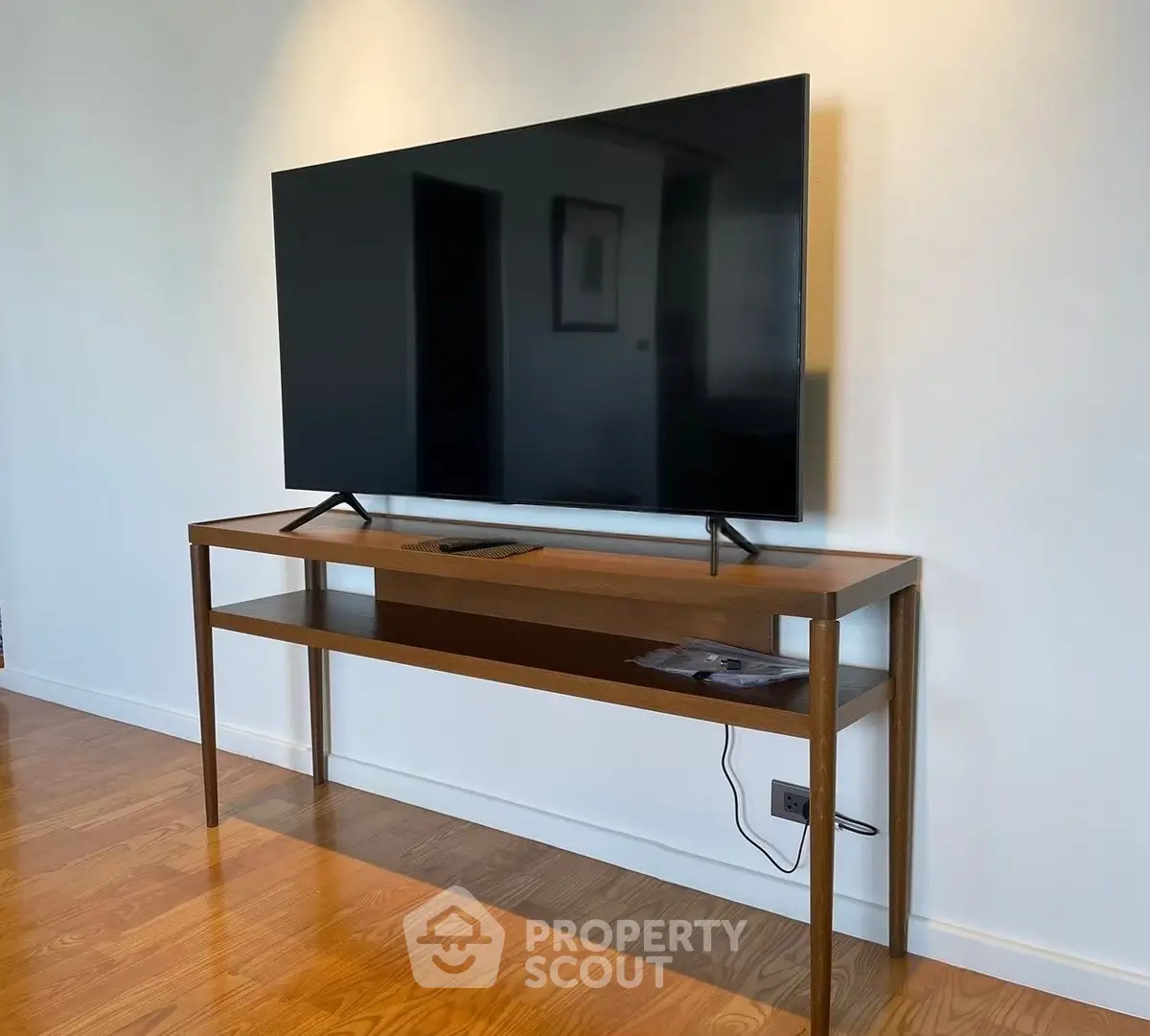 Modern living room with sleek TV setup on elegant wooden console table.