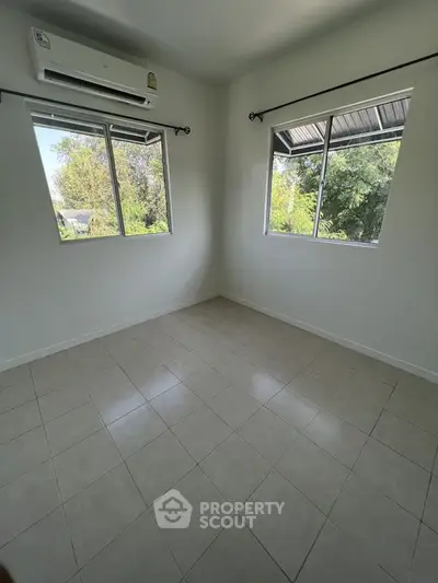 Bright empty room with tiled floor and large windows, ideal for customization.