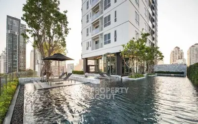 Luxurious high-rise building with stunning pool and cityscape view, perfect for urban living.