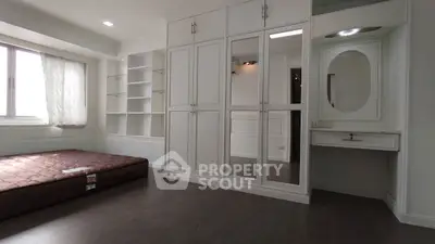 Spacious bedroom with built-in wardrobe and vanity in modern apartment
