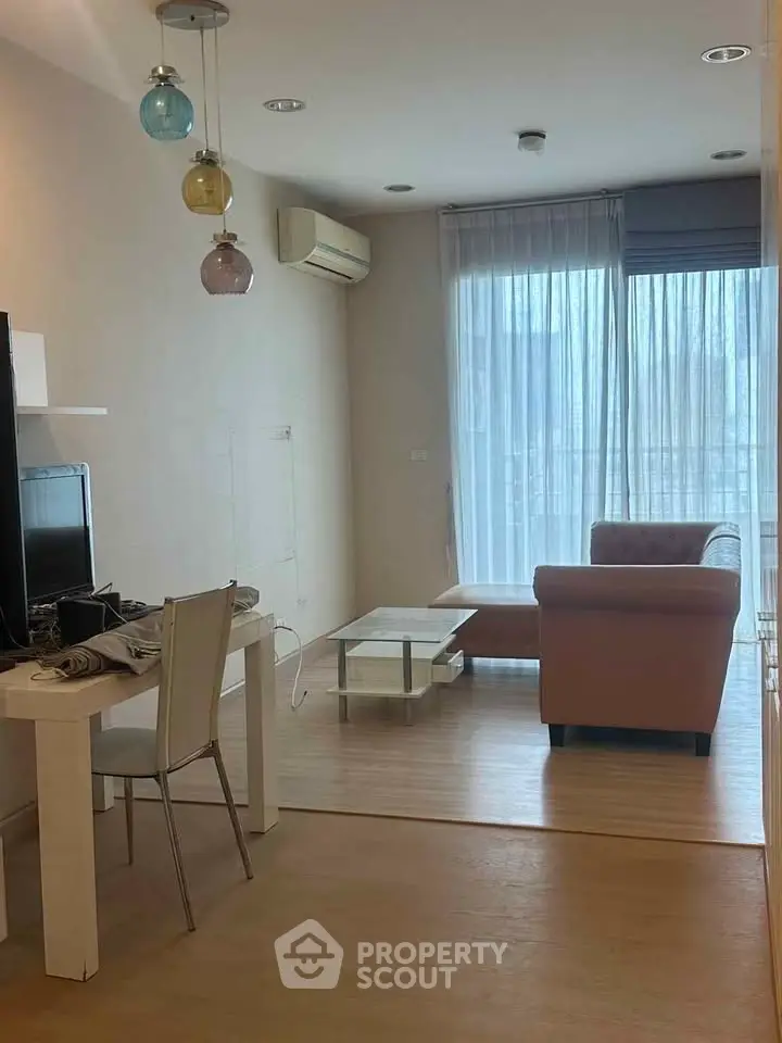 Modern living room with natural light, featuring a cozy sofa and stylish decor.