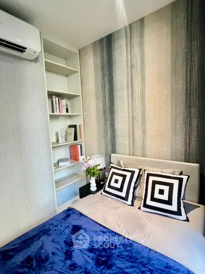 Modern bedroom with stylish decor and built-in shelving, featuring a cozy bed and elegant wall design.