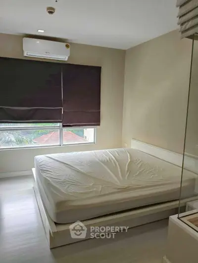 Spacious bedroom with large window and air conditioning in modern apartment