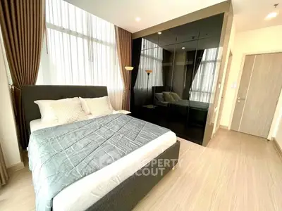 Modern bedroom with floor-to-ceiling windows and sleek black wardrobe