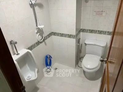 Compact bathroom with toilet, urinal, and shower in tiled interior.