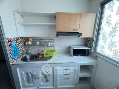 Compact kitchen with modern appliances and stylish backsplash