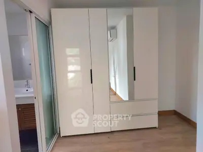 Modern bedroom with sleek wardrobe and sliding door to bathroom