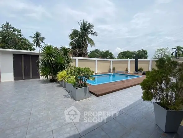 Luxurious outdoor pool area with modern landscaping and privacy walls.