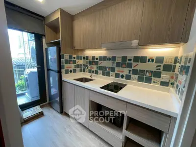 Modern kitchen with sleek cabinetry and stylish backsplash in urban apartment