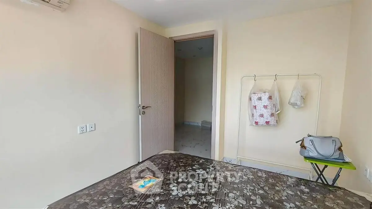 Cozy bedroom with open door and minimalistic decor, perfect for a serene living experience.