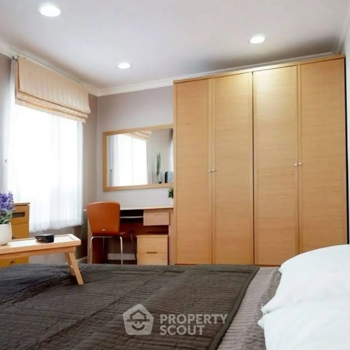 Cozy bedroom with modern furniture and ample natural light.