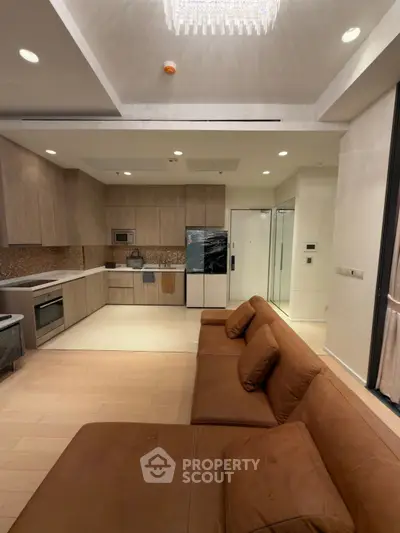 Luxurious open-layout kitchen and living room with modern appliances and elegant design.