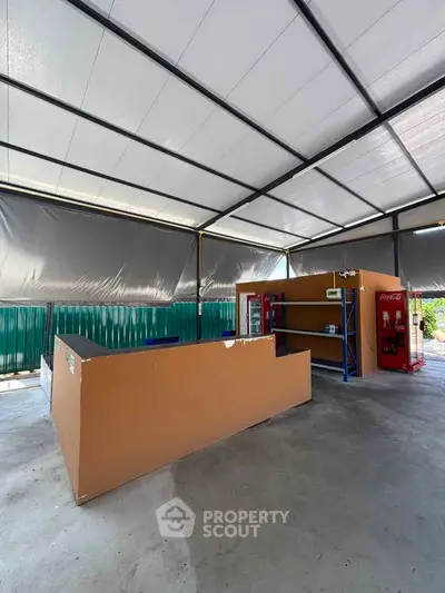 Spacious industrial-style open area with shelving and vending machine, ideal for commercial use.