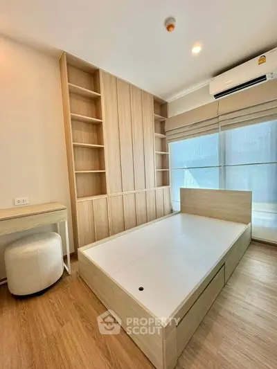 Modern bedroom with built-in wooden shelves and bed frame, featuring natural light and minimalist design.