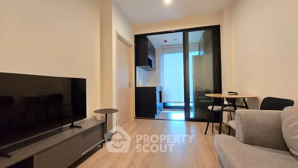 Modern living room with sleek furniture and open kitchen layout, perfect for urban living.