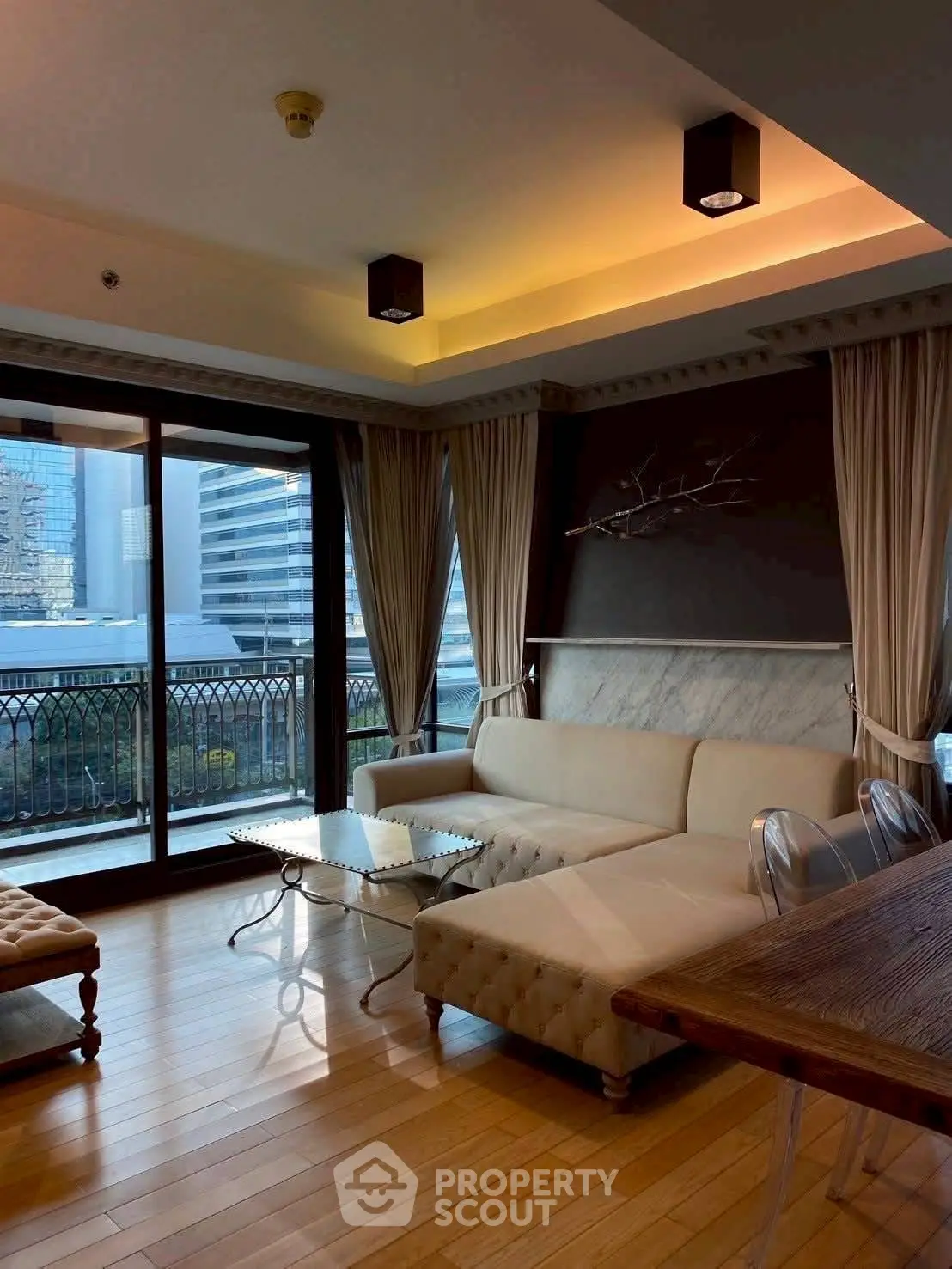Luxurious living room with elegant decor and city view balcony.