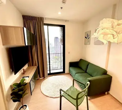 Modern living room with green sofa and balcony view in urban apartment