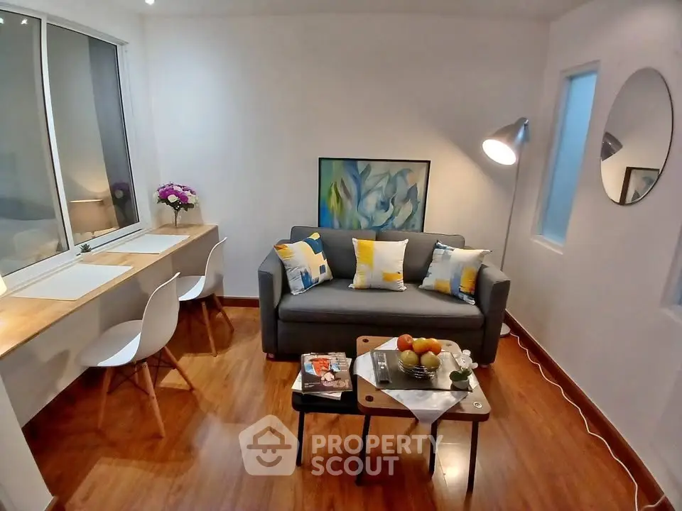 Cozy living room with modern decor, wooden flooring, and natural light