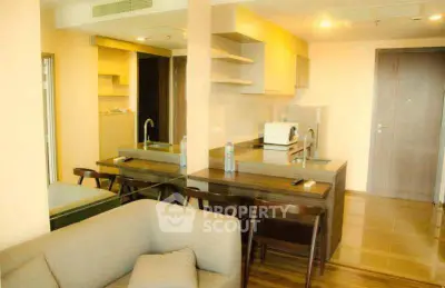 Modern open-layout kitchen and living area with sleek furniture and warm lighting.