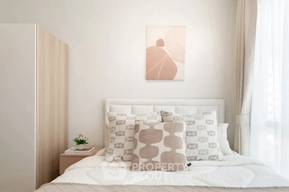 Elegant bedroom with modern decor and cozy bedding in a bright, minimalist style.