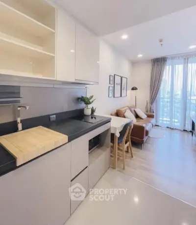 Modern open-plan kitchen and living room with stylish decor and natural light.