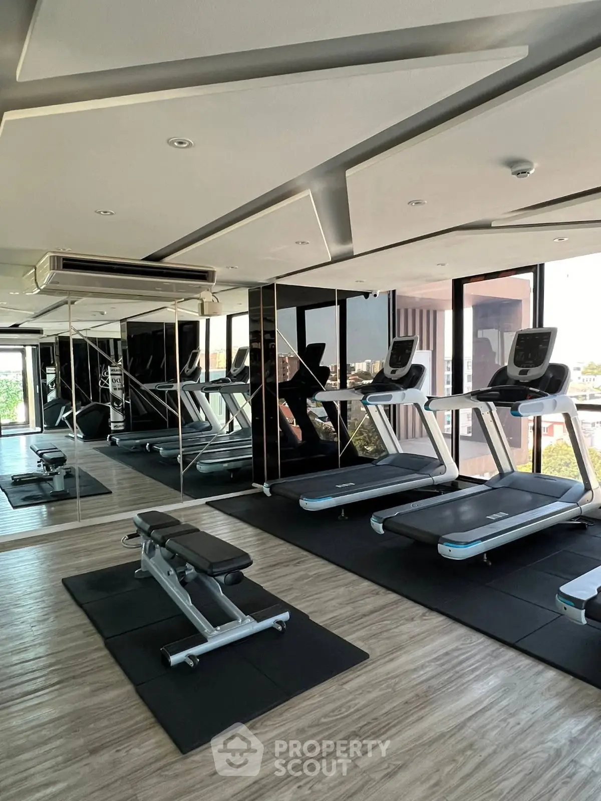 Modern gym with treadmills and weights in a luxury apartment building