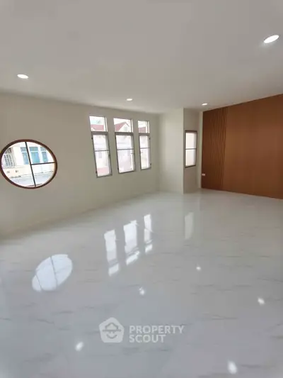 Spacious modern living room with large windows and elegant flooring