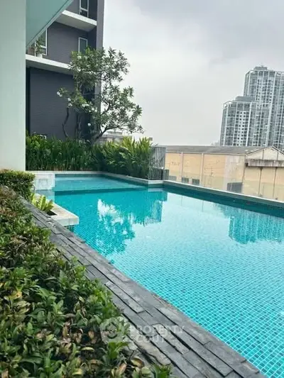 Luxurious rooftop pool with stunning cityscape views in modern high-rise building.