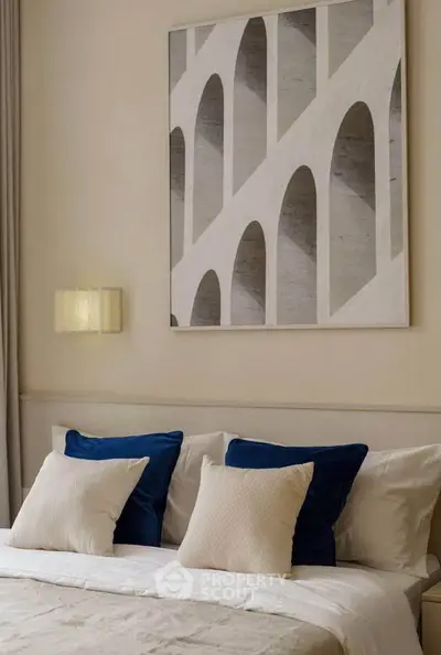 Elegant bedroom with modern art and plush pillows, perfect for a serene retreat.
