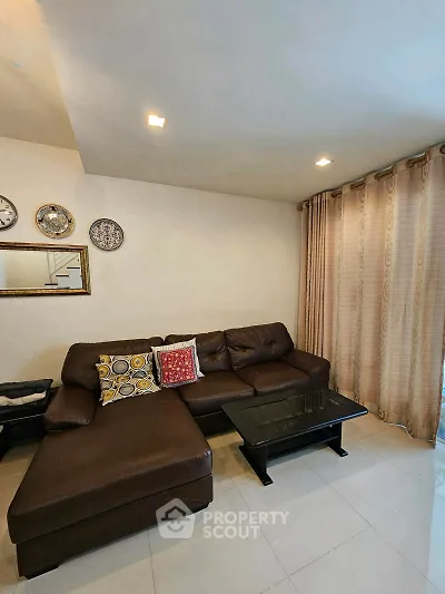 Cozy living room with stylish brown leather sectional sofa and elegant decor accents.