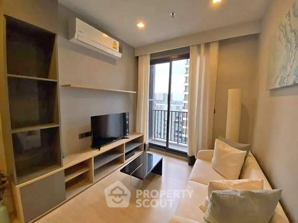 Modern living room with balcony view, featuring sleek furniture and air conditioning.