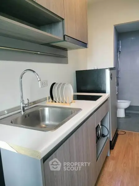 Modern compact kitchen with sleek cabinetry and integrated appliances