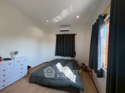 Cozy bedroom with natural light, modern decor, and air conditioning unit.