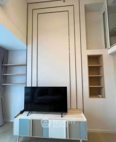 Modern living room with high ceiling and stylish TV stand in contemporary apartment.