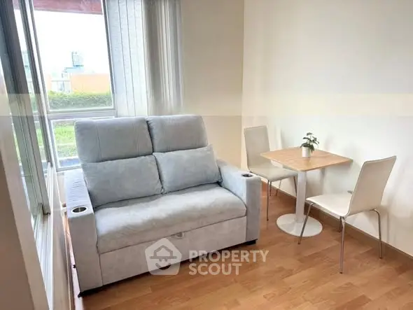 Cozy living room with modern sofa and dining set, bright natural light