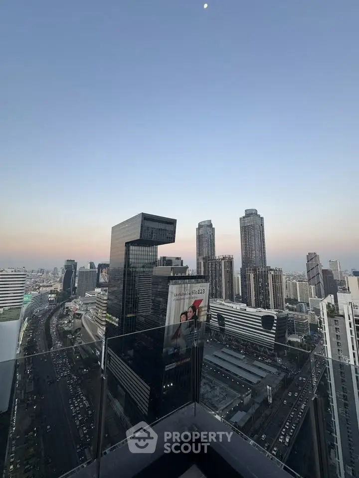 Stunning cityscape view from a high-rise balcony with modern skyscrapers and clear skies.